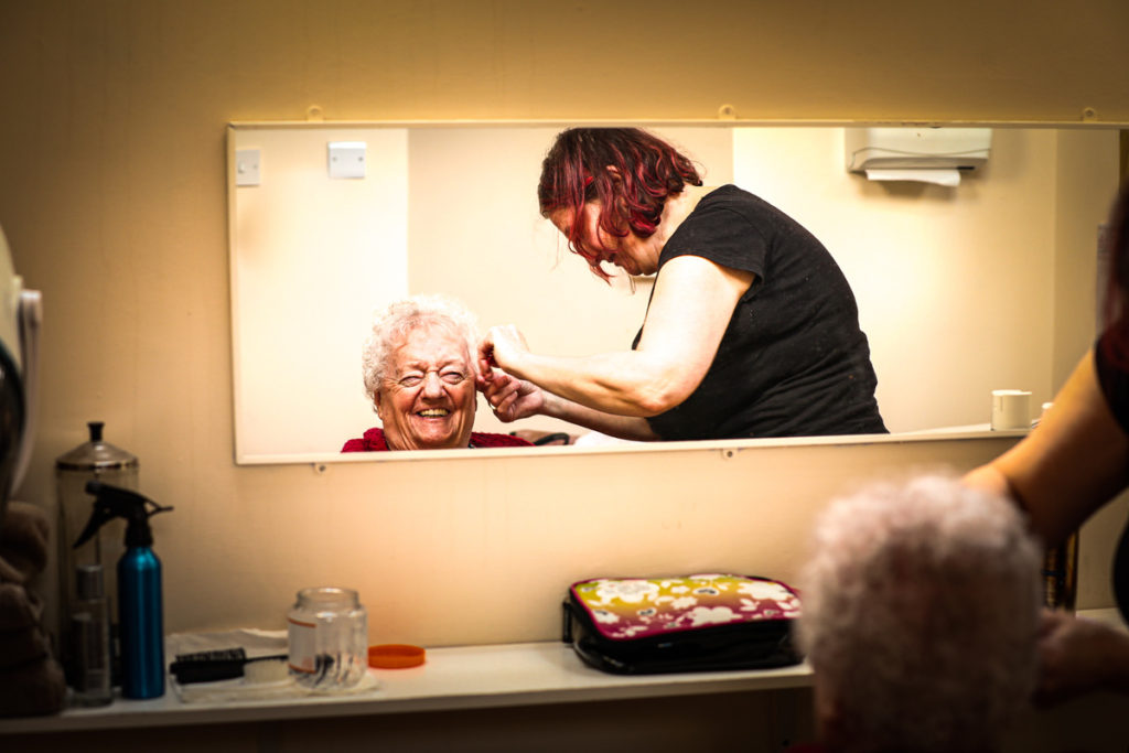A resident at Hilgay is delighted to have her hair done at the salon in house