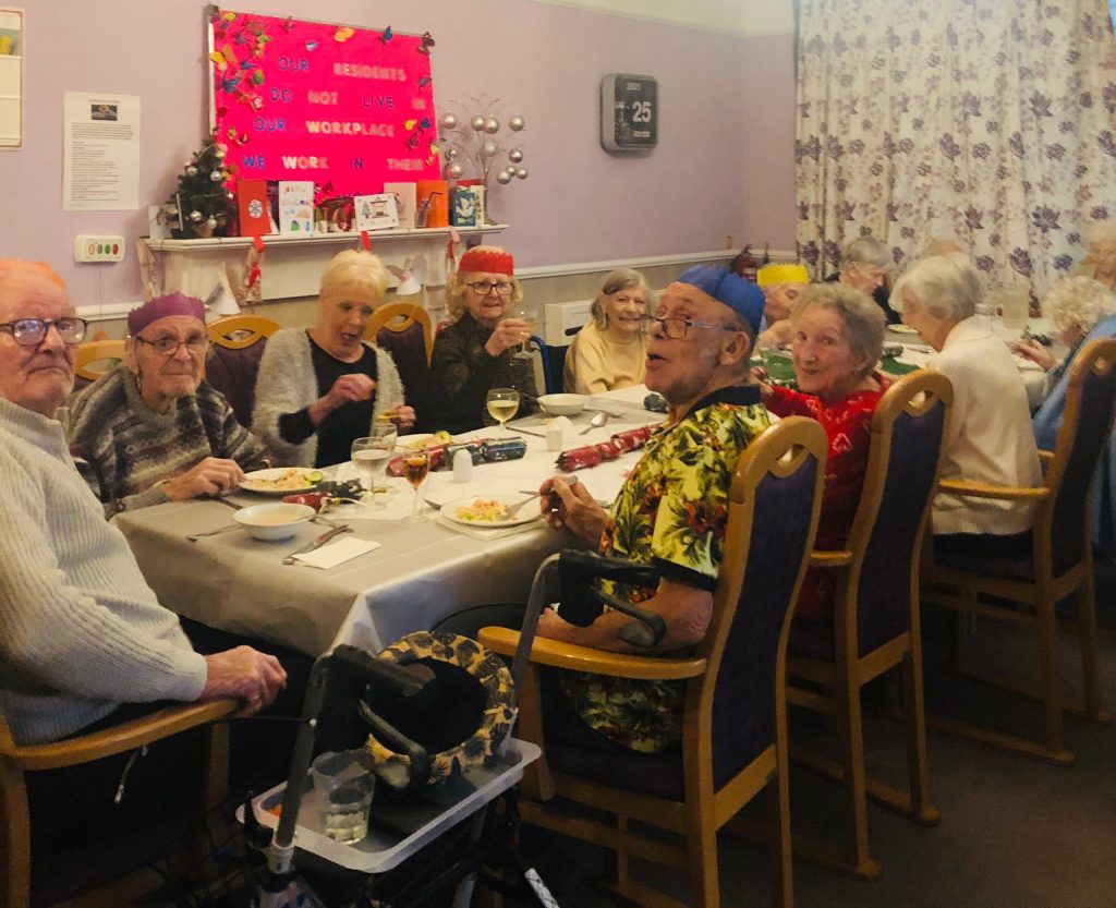 group of care home residents sad around the table together