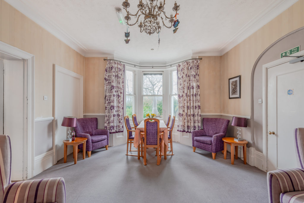large room with purple tables and chairs in front of a window