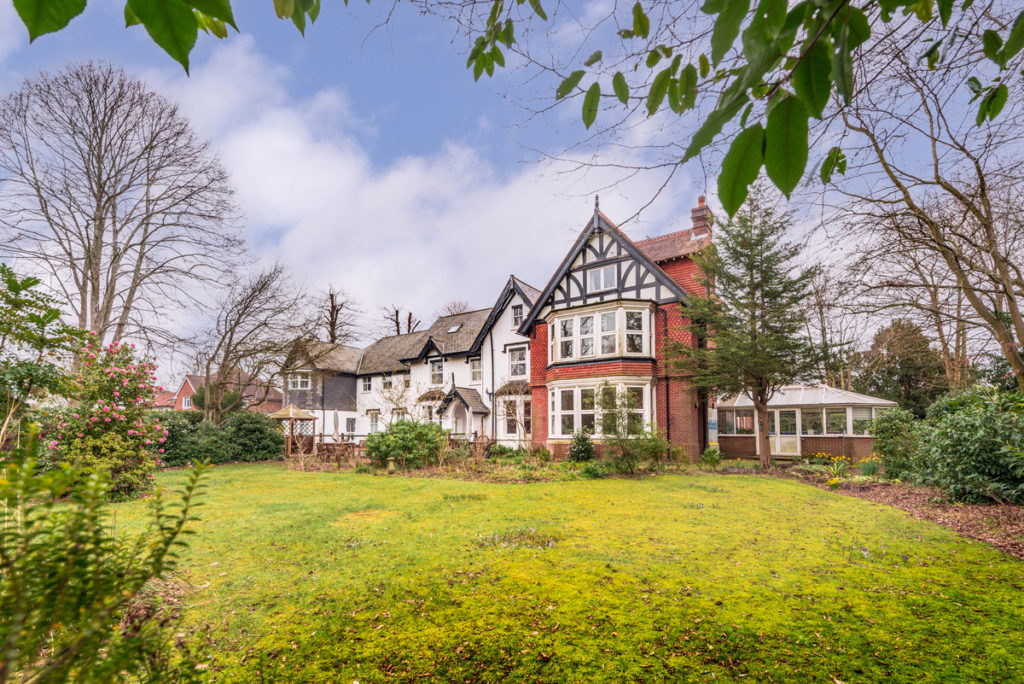 A large care home with a garden in front