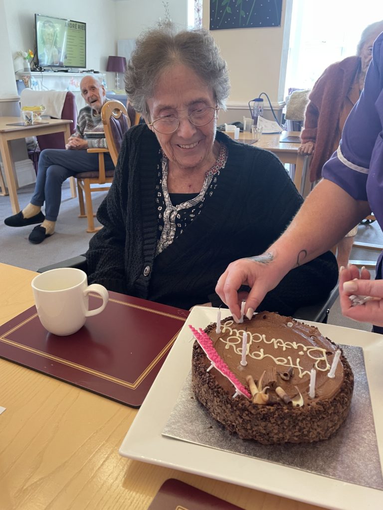 elderly woman in a care home being wished happy birthday