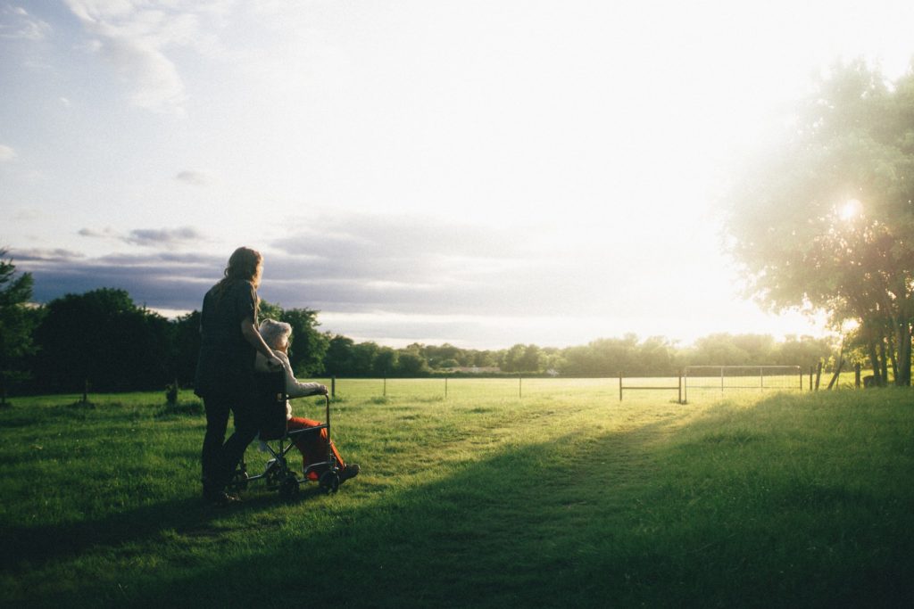 carer and resident walking in a garden at a care home